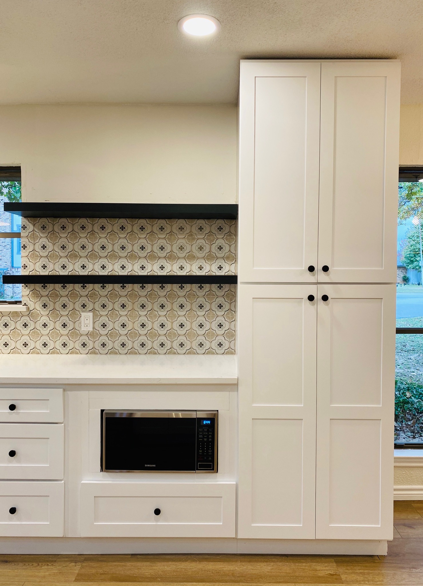 Bright kitchen with patterned tile feature wall and floating shelves