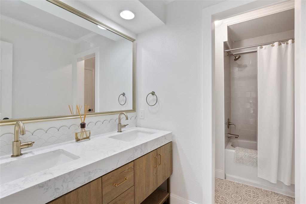 Spa-like bathroom with double vanity, soaking tub, and large mirror